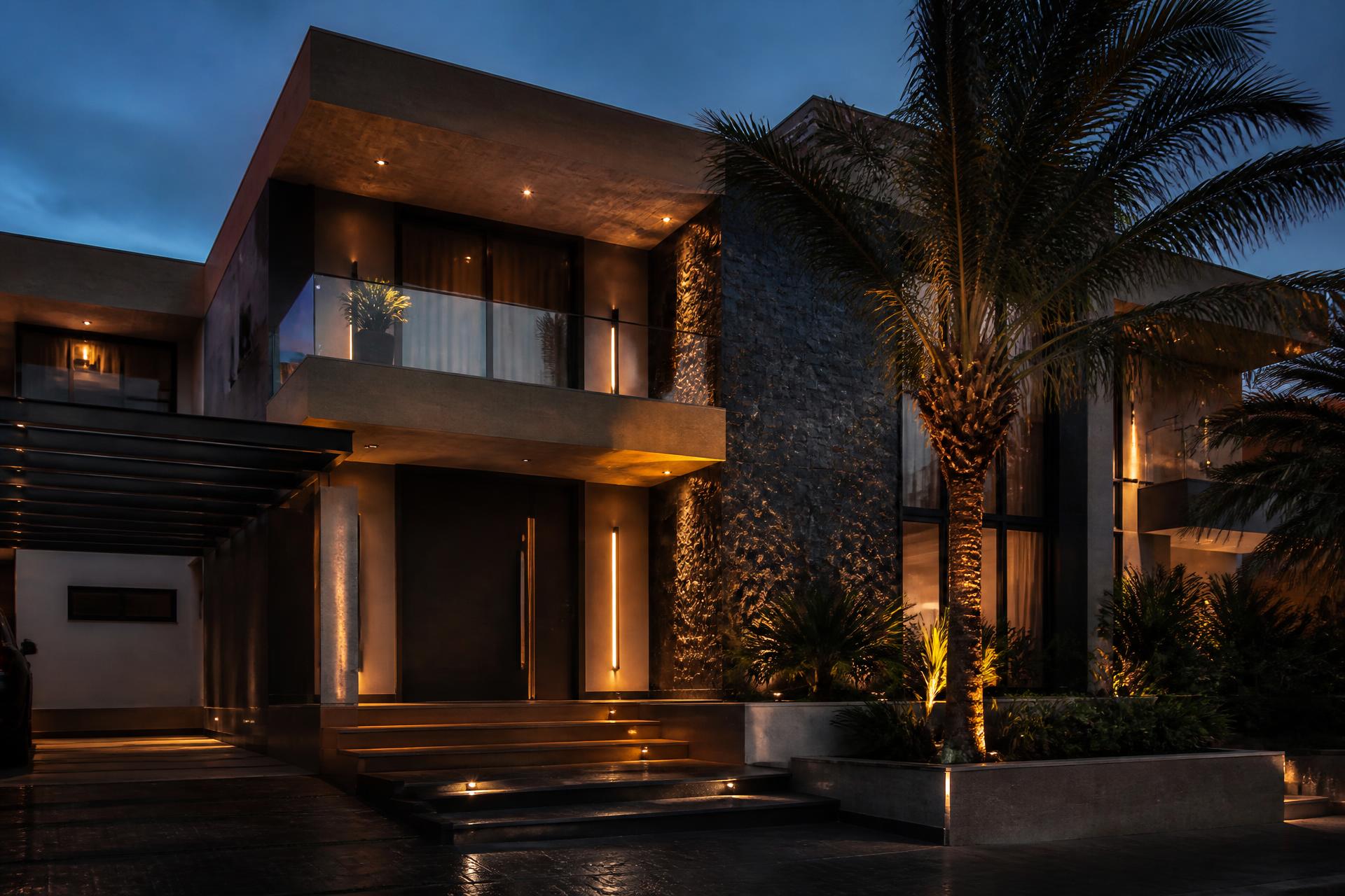 Luxury exterior of a modern Lagos villa at dusk with warm entrance lighting